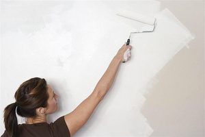 5 tips to prepare your home for showing. Woman painting a wall.