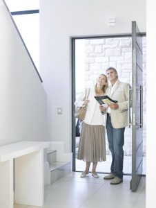 First impressions. Couple standing inside doorway admiring home.