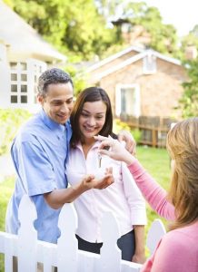 Six steps to a smooth home purchase. Young couple receiving house keys from agent.