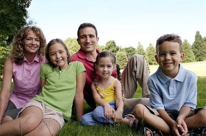 Happy family sitting outdoors.